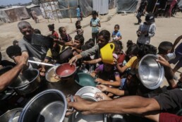 DISPLACED PALESTINIANS, INCLUDING CHILDREN, RECEIVE A HOT MEAL DISTRIBUTED BY AN AID ORGANIZATION IN ZAWAIDA, JUNE 27, 2024.