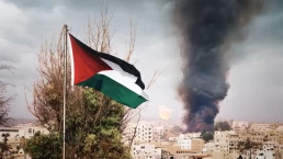 a palestinian flag with a burning building in the background