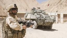 a pakistani soldier stands near a tank