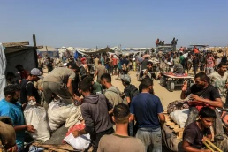 Palestinians receive humanitarian and food aid from the American Center for Humanitarian Aid (GHF), located in Rafah, southern Gaza Strip, on August 14, 2025.