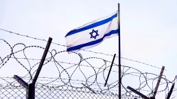 View of israeli flag behind barbed wire against cloudy sky. border post on the border of israel. The checkpoint at the embassy of the country. the Palestinian-Israeli border.