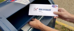 Circa August, 2020 - A man puts an absentee mail-in ballot in the mailbox.