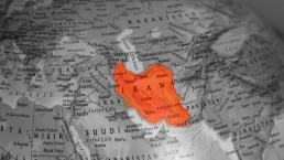 The United States and Iran are on the brink of war. The map of Iran is highlighted in red on the globe model. A section of the world map. Middle Eastern countries. Political tension or crisis. Top view, above, up. No people, nobody. Horizontal photo.