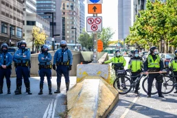 Boston, Massachusetts, USA – October 18, 2020: Police officers and bicycle patrol officers stand near a downtown street during a public demonstration in Boston.
