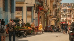 Havana, Cuba 2024 Apr16 - Scene of everyday daily life of locals in Old Havana. People walking on the streets, vendors selling fruits in carts. Bustling vibrant city life in neighborhood.