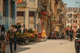 Havana, Cuba 2024 Apr16 - Scene of everyday daily life of locals in Old Havana. People walking on the streets, vendors selling fruits in carts. Bustling vibrant city life in neighborhood.