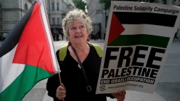 English: Palestine solidarity protester with Palestinian flag and 